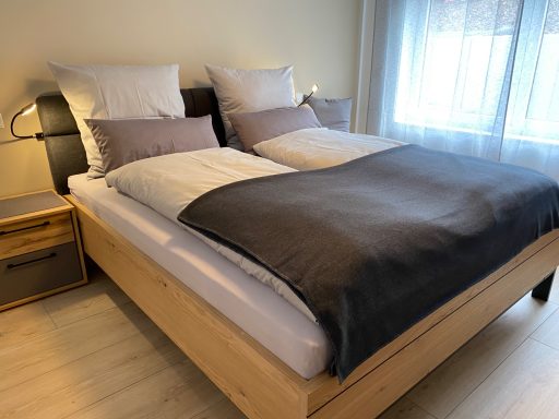 SCHLAFZIMMER MIT DOPPELBETT Doppelbett mit graßer Bettdecke und Kissen in modernem Schlafzimmer.